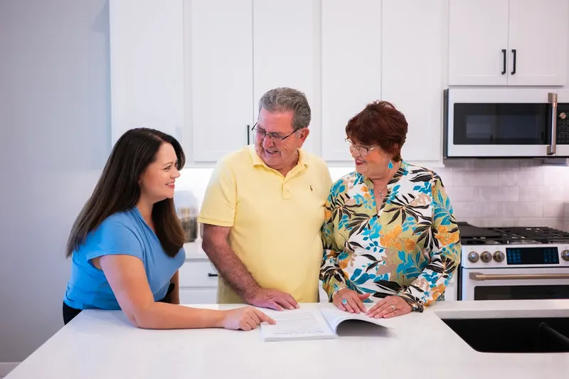 Viola Lucero talking through coverage with a couple at their kitchen counter